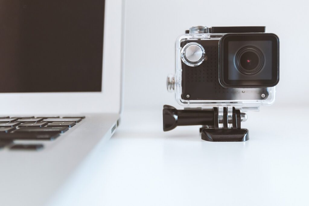 Black gopro and silver Laptop